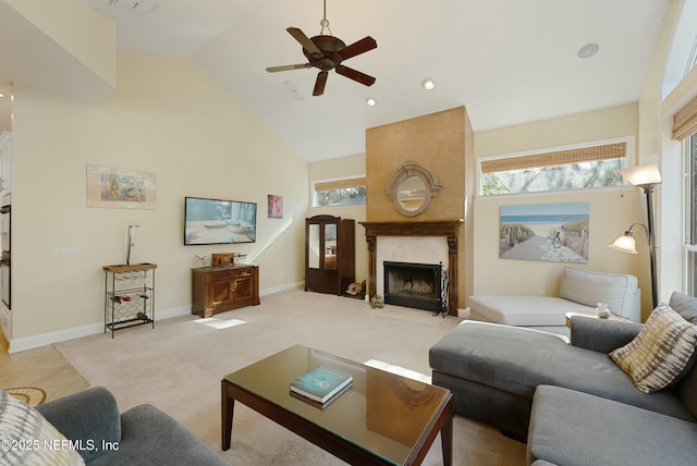 living room featuring baseboards, a wealth of natural light, a high end fireplace, and light colored carpet