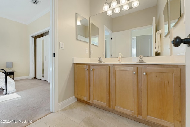 bathroom with a sink, visible vents, baseboards, tile patterned floors, and double vanity