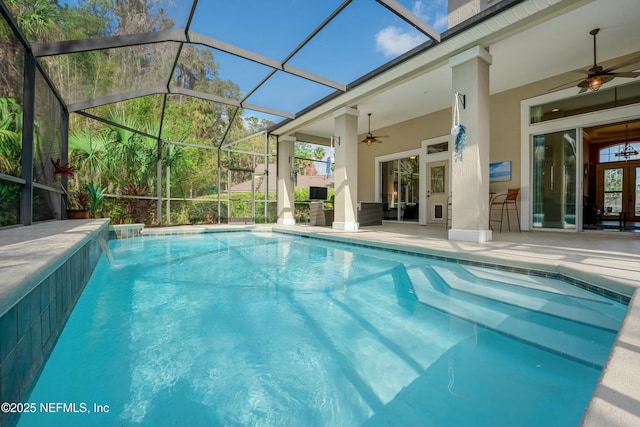 outdoor pool featuring a ceiling fan, glass enclosure, and a patio