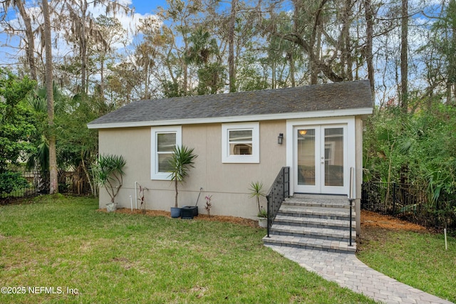 view of front of property with french doors, roof with shingles, fence, and a front lawn