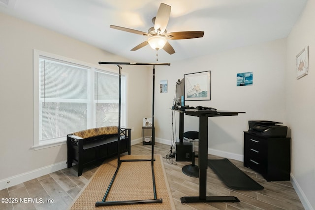 workout room featuring wood finish floors, a ceiling fan, and baseboards