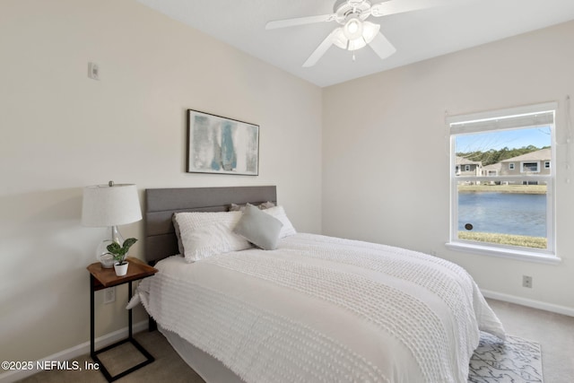 carpeted bedroom with ceiling fan and baseboards