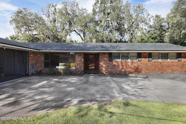 ranch-style house with brick siding, driveway, and an attached garage