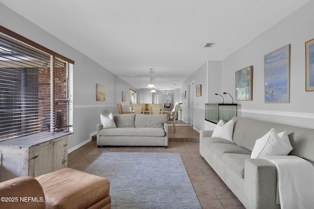 tiled living area with visible vents and baseboards