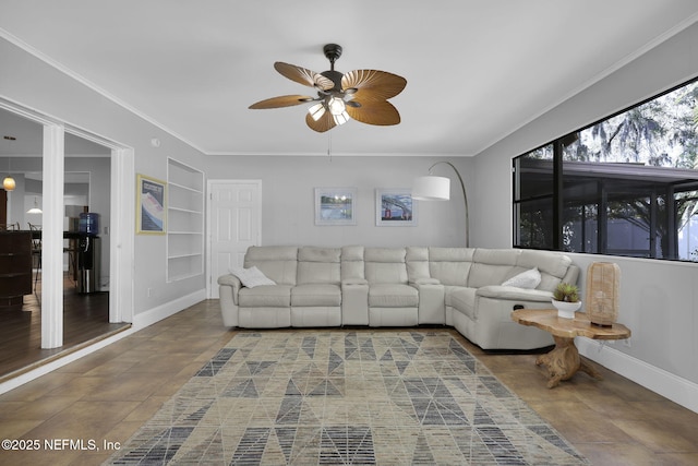 living area featuring ornamental molding, built in shelves, baseboards, and a ceiling fan