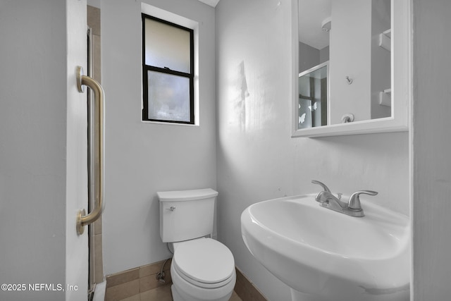 bathroom with toilet, baseboards, and a sink