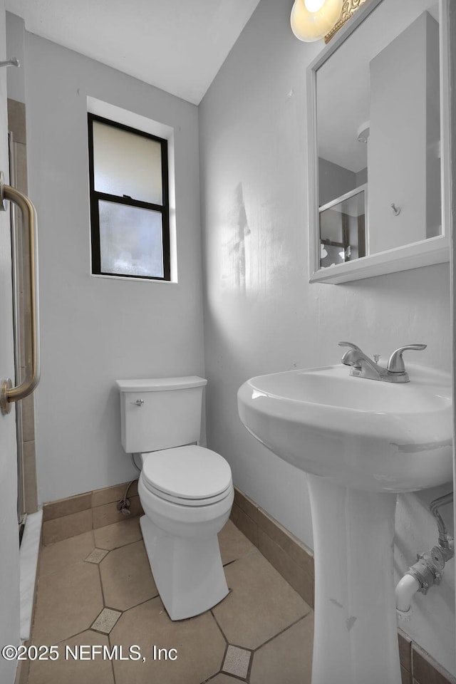 bathroom with toilet, tile patterned flooring, and baseboards