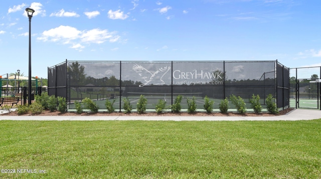 view of sport court with a lawn