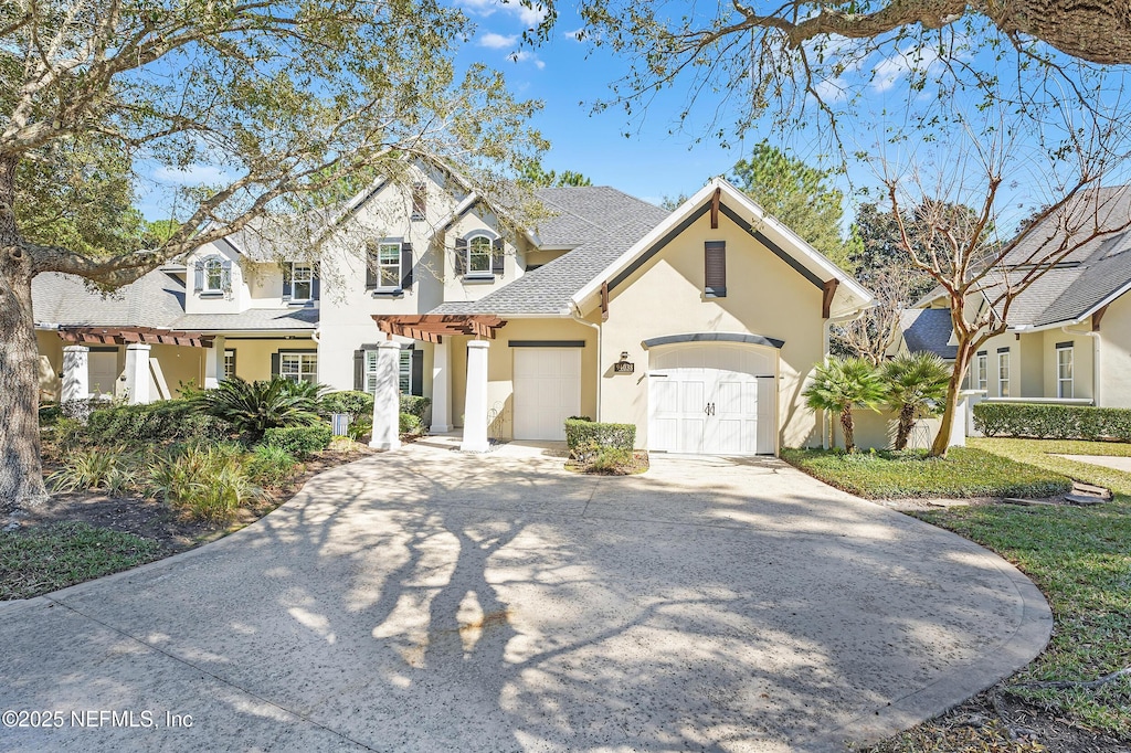 94038 Hemlock Ct, Fernandina Beach, FL 32034 - view of front of property featuring driveway, a shingled roof, an attached garage, and stucco siding
