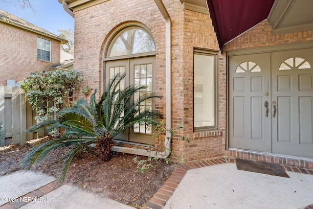 view of exterior entry featuring brick siding