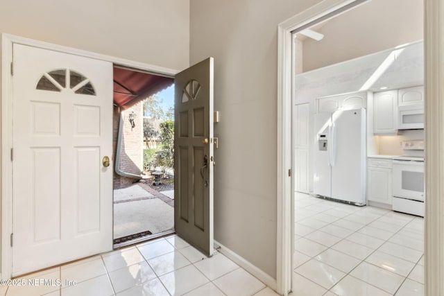 entrance foyer with light tile patterned floors and baseboards