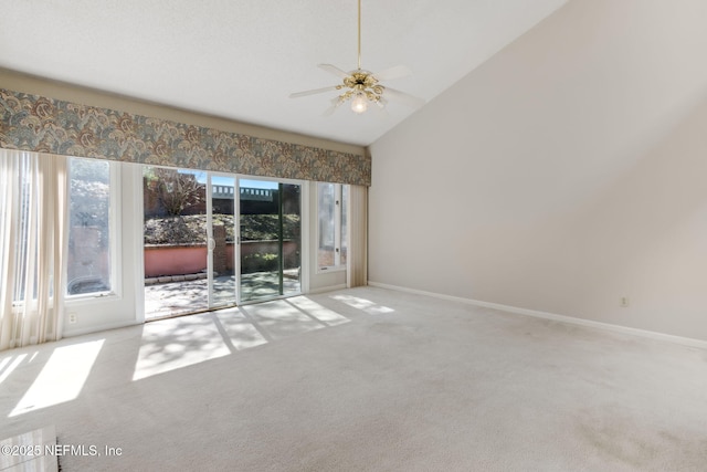 empty room with a ceiling fan, light colored carpet, high vaulted ceiling, and baseboards