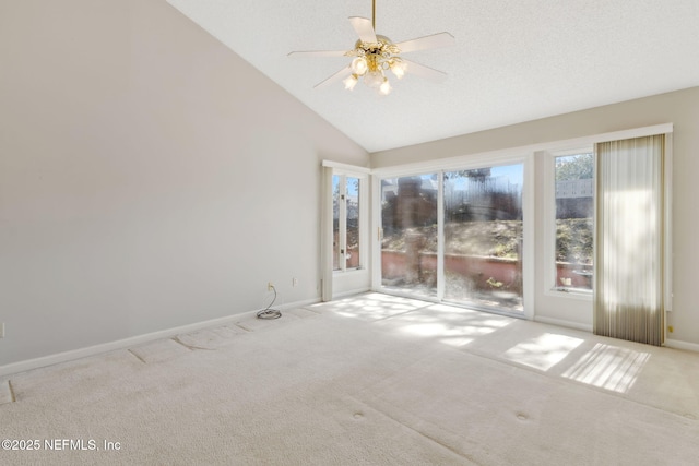 empty room featuring light carpet, baseboards, vaulted ceiling, and a textured ceiling