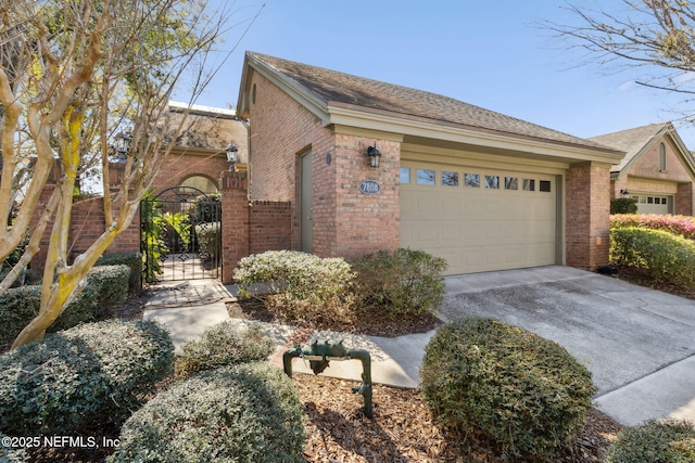 view of front of house with a garage, brick siding, concrete driveway, roof with shingles, and a gate