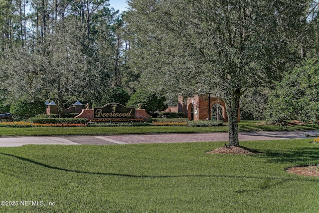 view of home's community with driveway and a lawn