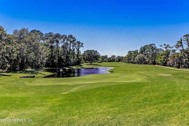 view of home's community with view of golf course, a water view, and a lawn