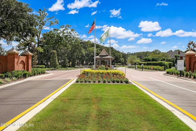 view of street with curbs and a gated entry