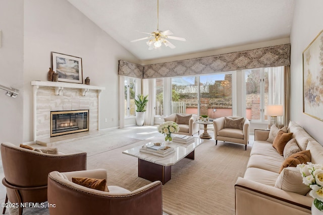 living area with a ceiling fan, high vaulted ceiling, and a premium fireplace