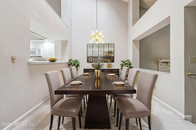 dining room featuring baseboards, a high ceiling, and a chandelier