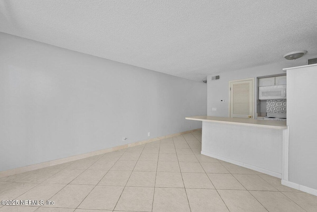 1255 Ponce Island Dr Unit C-733, Saint Augustine, FL 32084 - unfurnished living room featuring visible vents, a textured ceiling, and baseboards