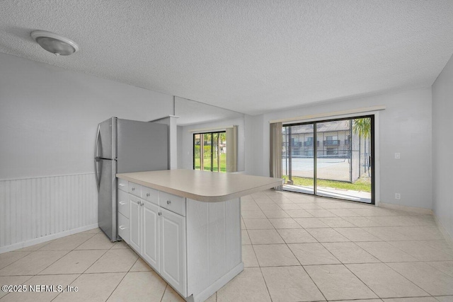 1255 Ponce Island Dr Unit C-733, Saint Augustine, FL 32084 - kitchen featuring freestanding refrigerator, light tile patterned flooring, a textured ceiling, and light countertops