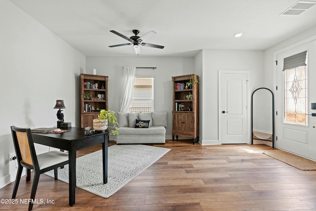 office area featuring a ceiling fan, baseboards, visible vents, and light wood finished floors