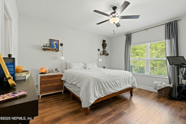 bedroom featuring a ceiling fan, baseboards, and hardwood / wood-style floors