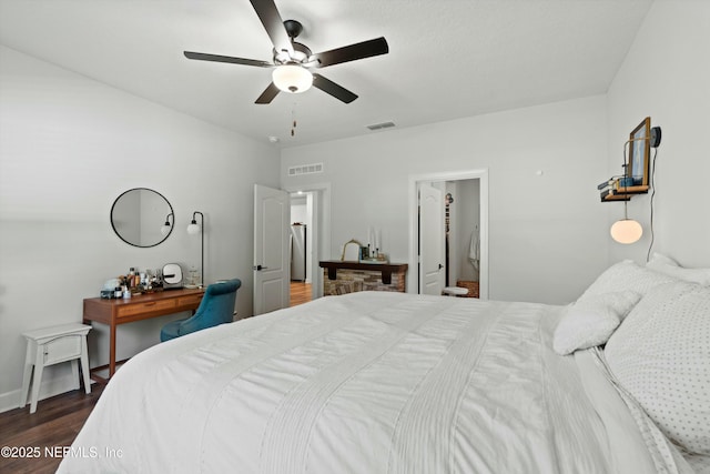 bedroom featuring ceiling fan, visible vents, and dark wood-style flooring