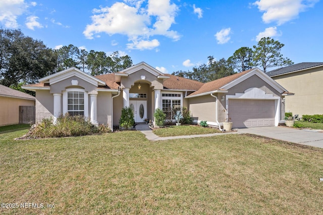 mediterranean / spanish house with driveway, an attached garage, a front yard, and stucco siding