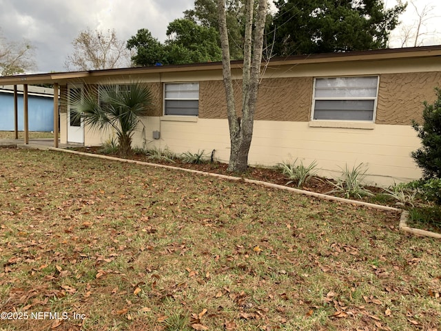 view of side of property featuring concrete block siding and a yard