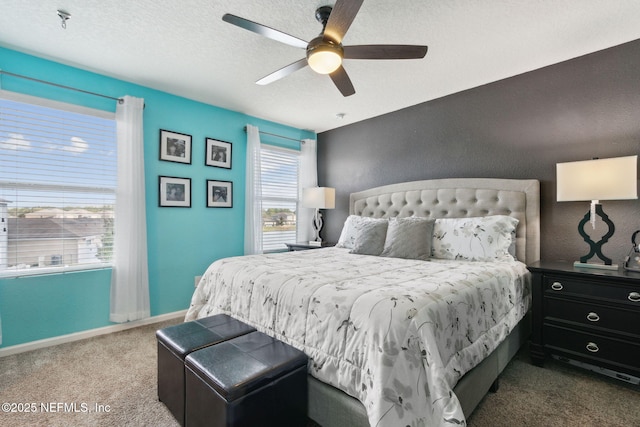 carpeted bedroom with a textured ceiling, a ceiling fan, and baseboards