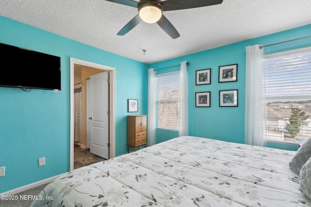 bedroom featuring a textured wall, a textured ceiling, and ceiling fan