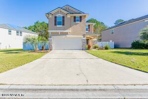 view of front of property featuring driveway, a garage, and a front yard