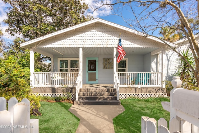 bungalow featuring covered porch and a front lawn