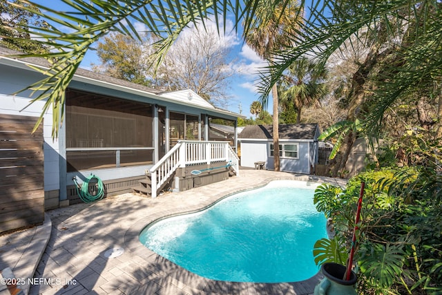 pool with a sunroom, a patio area, and fence