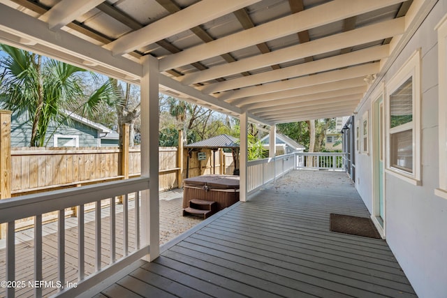 deck with a fenced backyard and a hot tub