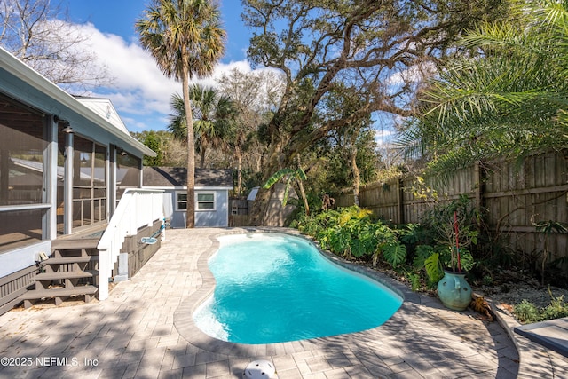 view of swimming pool with a fenced in pool, a sunroom, a fenced backyard, and stairs