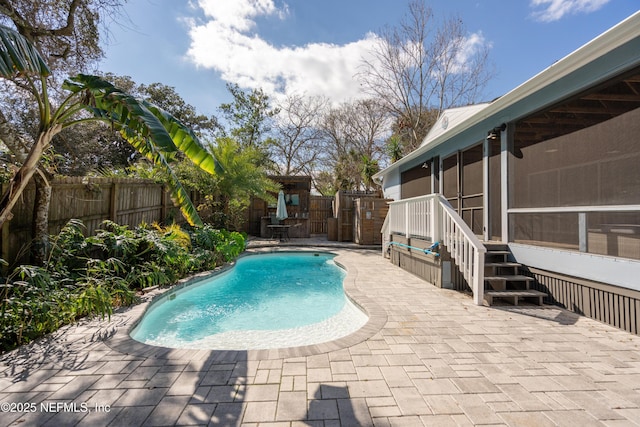 view of pool featuring a patio area, a fenced backyard, a sunroom, and a fenced in pool