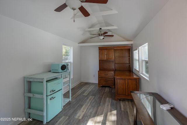 unfurnished office featuring dark wood-style floors, plenty of natural light, baseboards, and vaulted ceiling