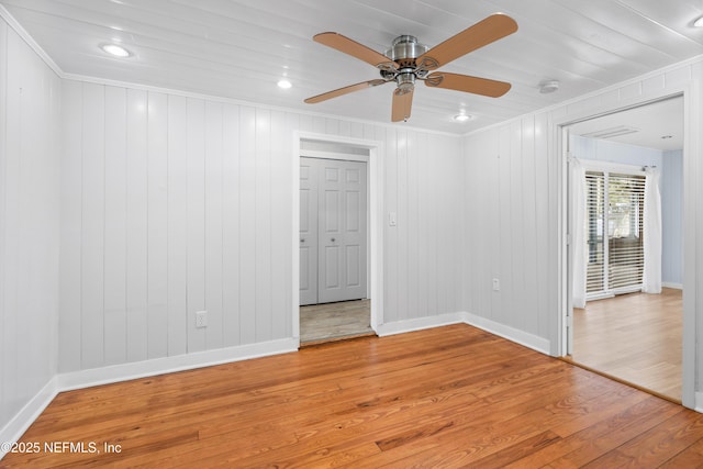 unfurnished room featuring crown molding, baseboards, and wood finished floors