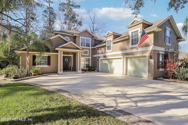 view of front of home featuring driveway, an attached garage, and stucco siding