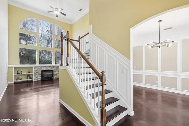 stairway featuring finished concrete floors, a decorative wall, and a high ceiling