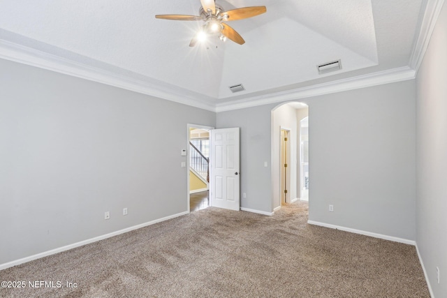 carpeted empty room featuring baseboards, visible vents, arched walkways, and crown molding