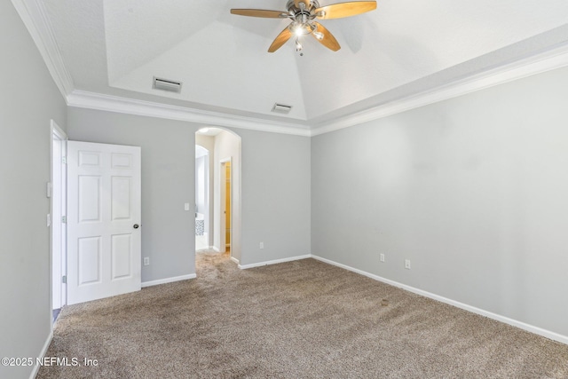 spare room with arched walkways, visible vents, crown molding, and carpet