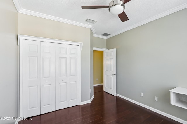 unfurnished bedroom with visible vents, crown molding, baseboards, and wood finished floors