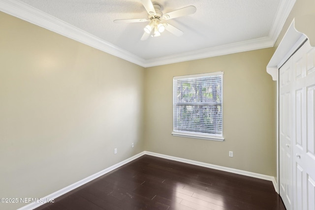 unfurnished room featuring a ceiling fan, crown molding, dark wood finished floors, and baseboards