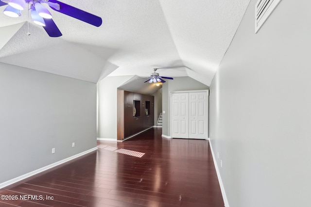 additional living space featuring ceiling fan, a textured ceiling, lofted ceiling, wood finished floors, and visible vents