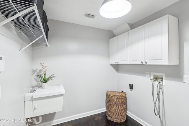 washroom featuring cabinet space, visible vents, baseboards, hookup for a washing machine, and hookup for an electric dryer