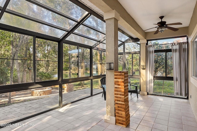 unfurnished sunroom featuring a ceiling fan