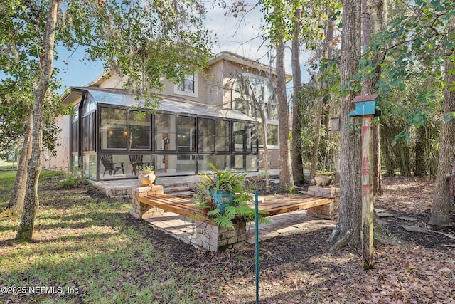 rear view of house featuring a sunroom